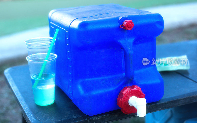 野餐桌上的大蓝色热水瓶/冷却器